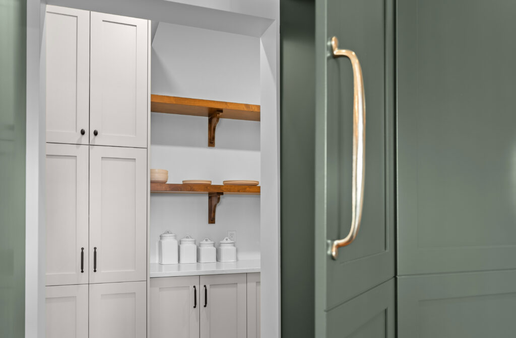 Pantry with shaker cabinets, open wood shelves, and brass handle captured for builder photography in Kingston Ontario