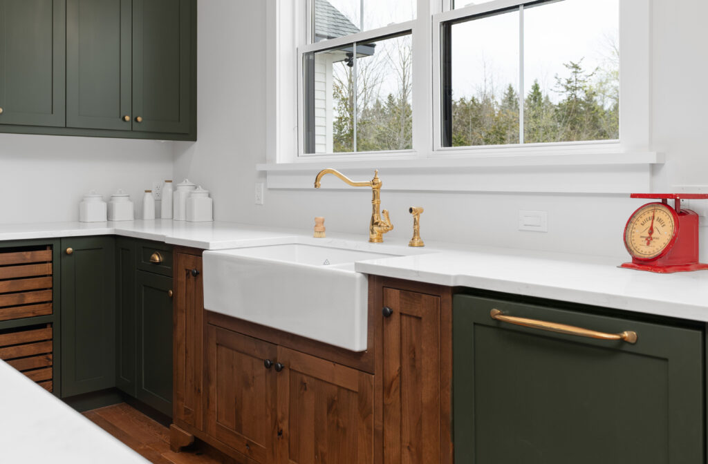 Farmhouse sink with brass faucet and two tone cabinetry in a Kingston Ontario new build