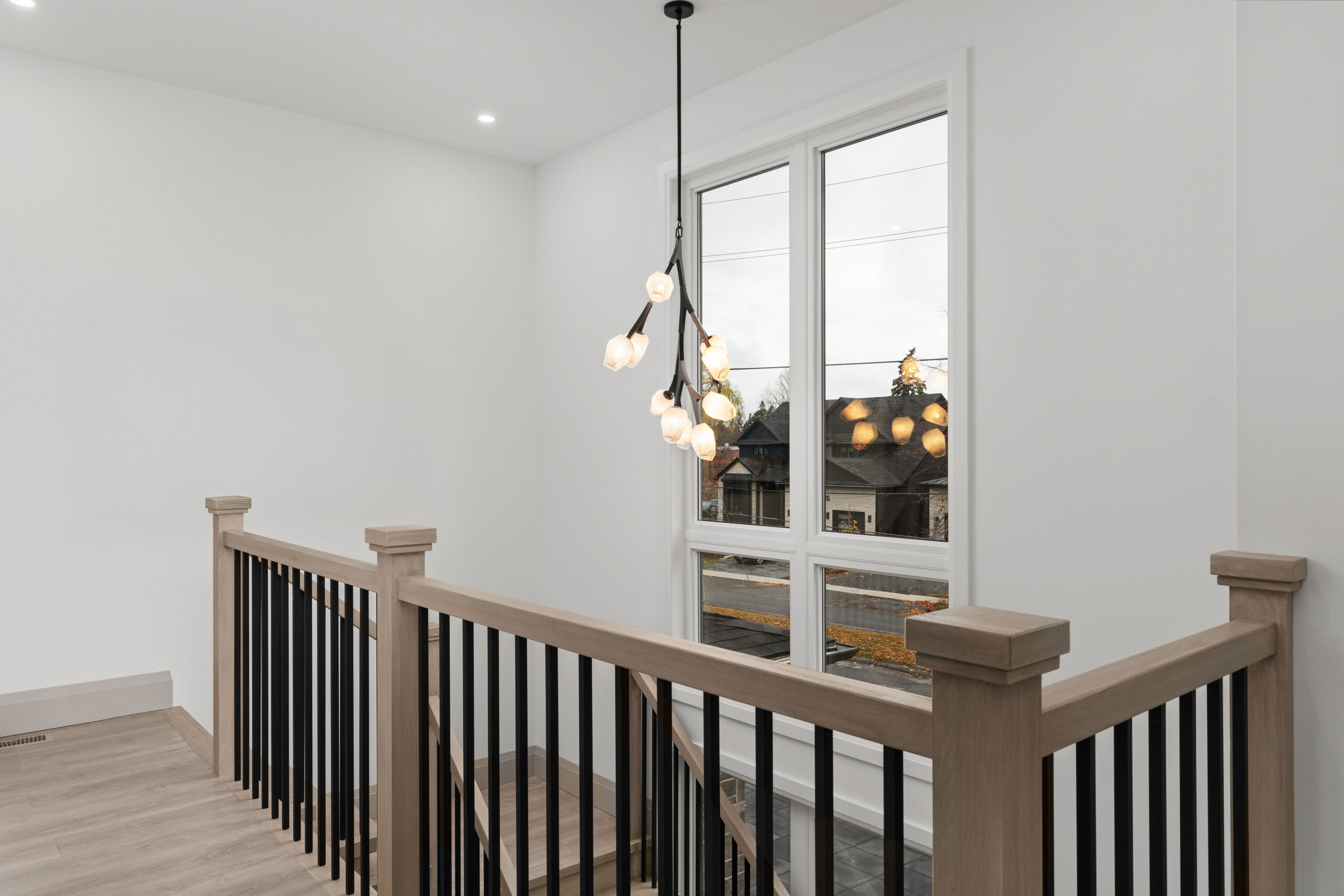 Custom staircase with black spindles and modern pendant light photographed for a Kingston home builder portfolio