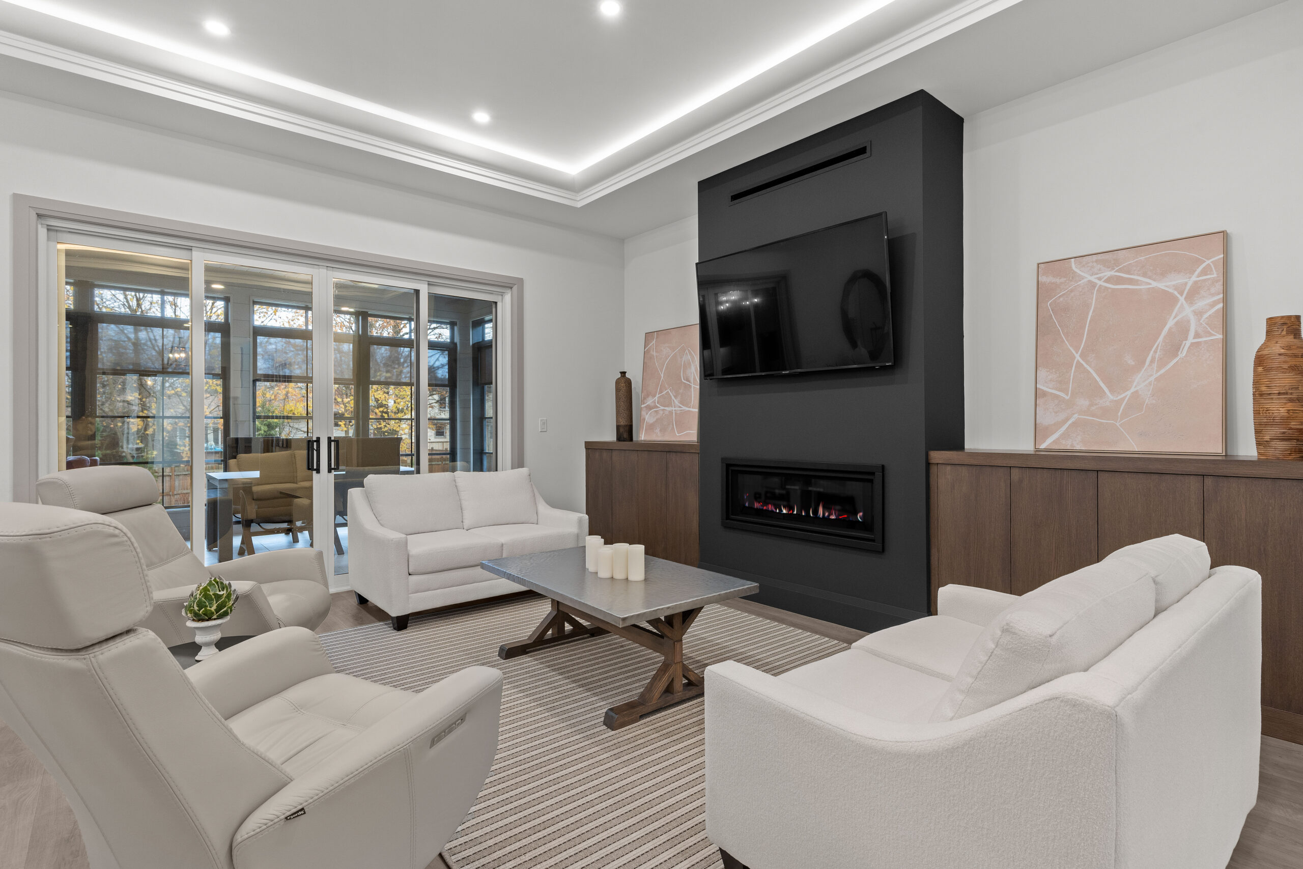 Open concept living room with feature fireplace, modern furniture, and large windows captured for a Kingston builder